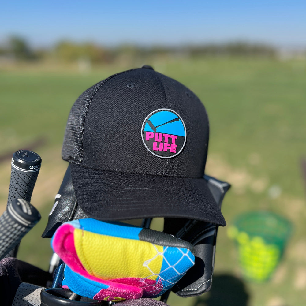 Putt life golf blue and pink putter logo black trucker snapback hat front