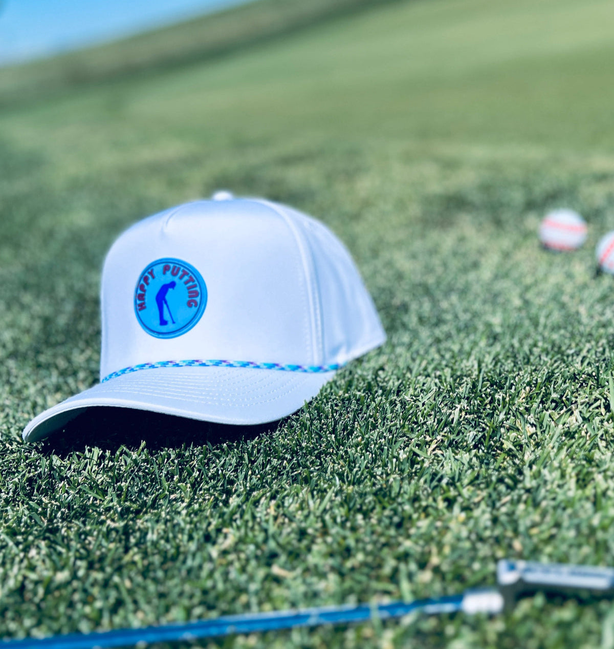 putt life golf happy putting white with blue and multi colored rope hat front in grass