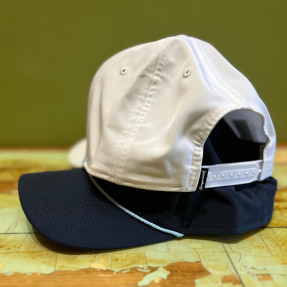 putt life golf happy putting white with blue rope hat and navy with light blue rope hat on table showing imperial brand and snapback